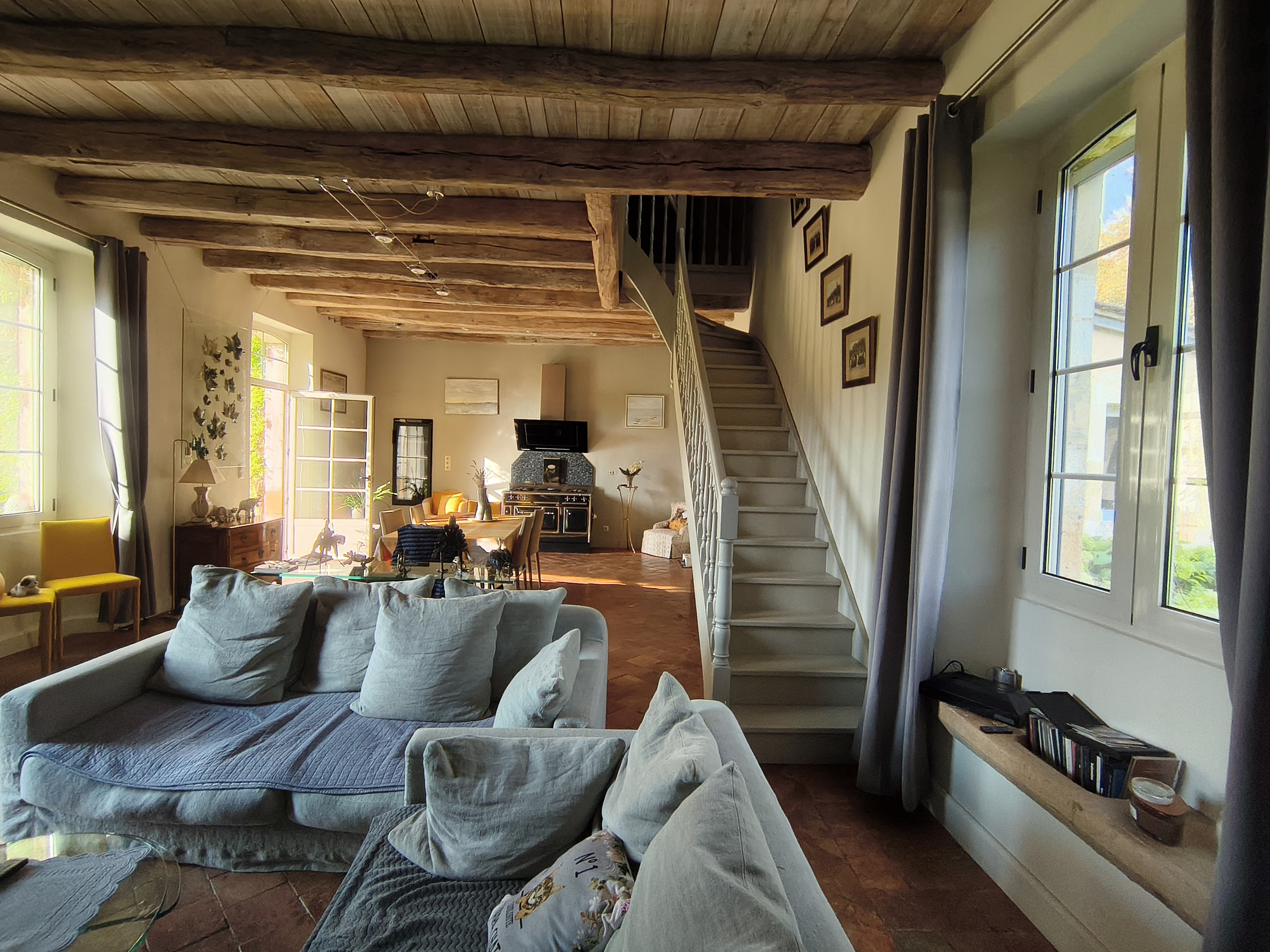 Grand salon avec poutres apparentes et escalier